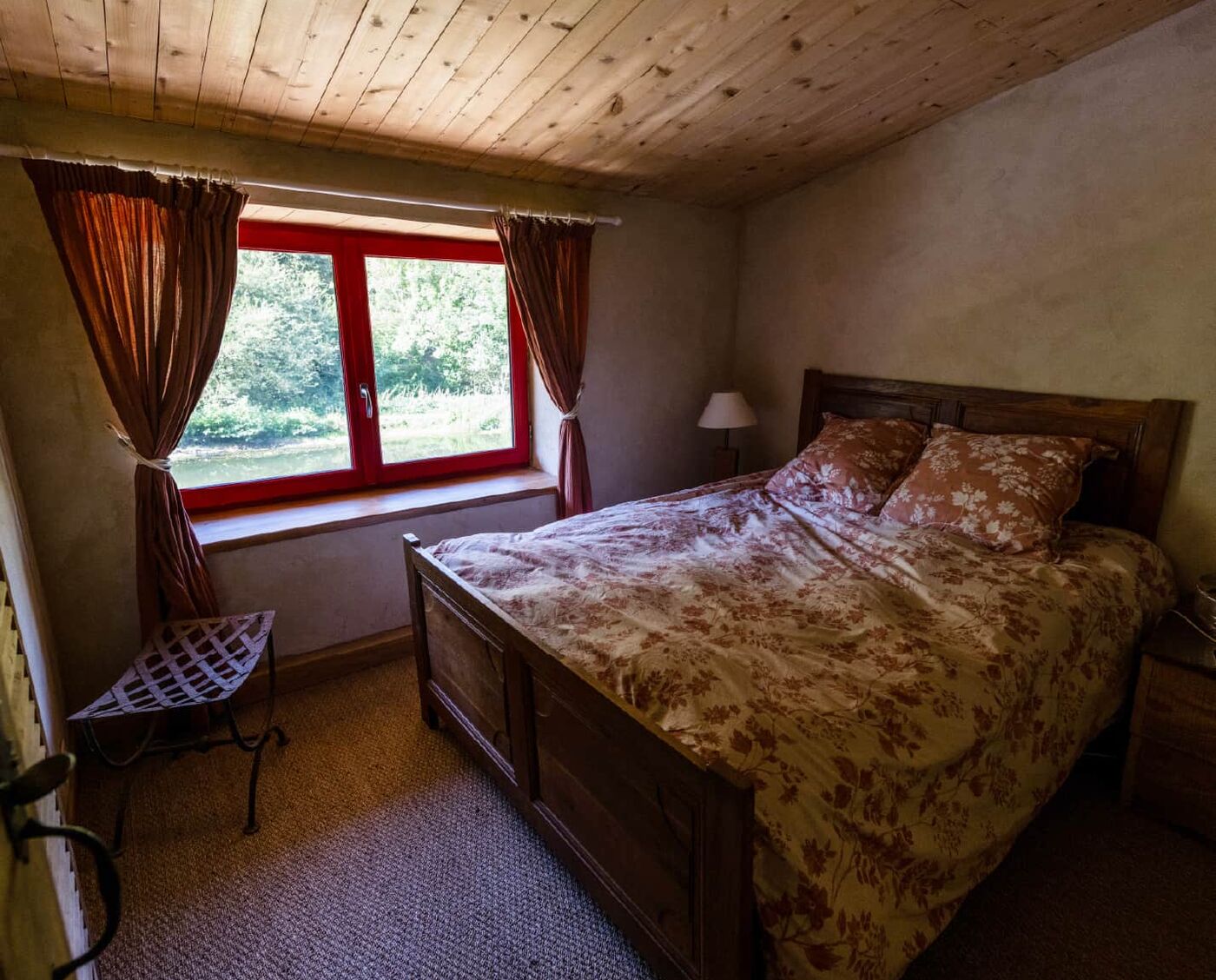 Chambre à la couette fleurie et aux rideaux rouges