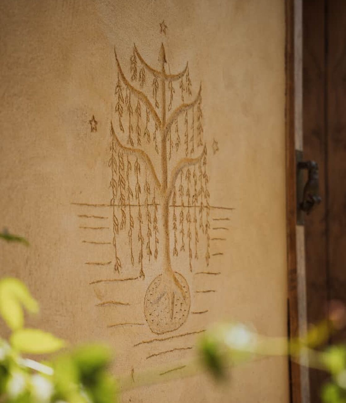 L'arbre de vie gravé sur le mur de terre de la grange